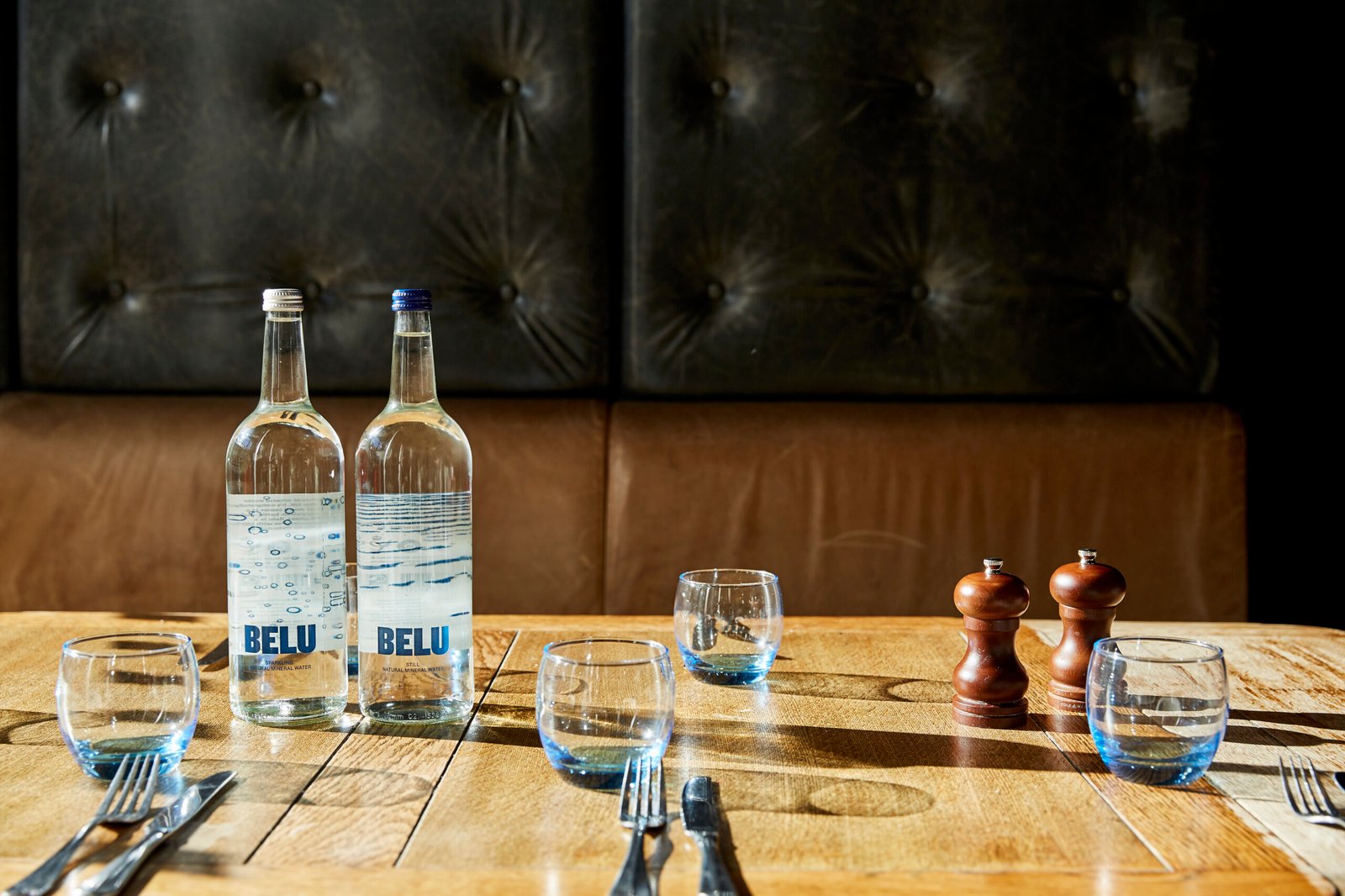 Bottled mineral water on a hotel dining table setting